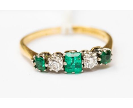 An emerald and diamond ring, set with alternate square cut emeralds with round cut diamonds in between, set in 18ct gold, siz