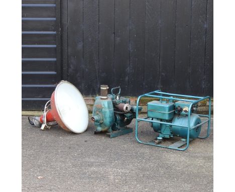 A petrol generator, together with a water pump, and a red painted industrial light
