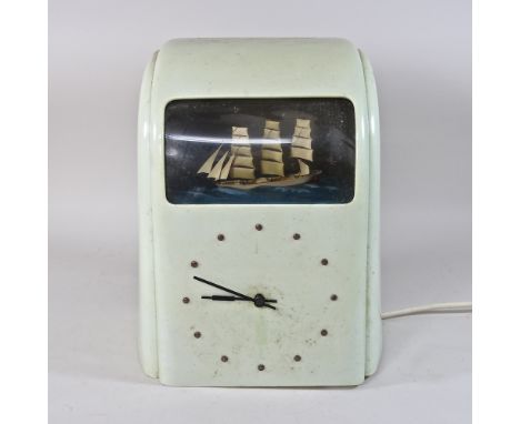 A 1930's white bakelite cased electric Vitascope automaton clock, inset with a three masted ship, 33cm high