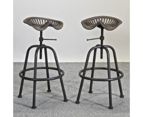 A pair of metal revolving tractor seat bar stools