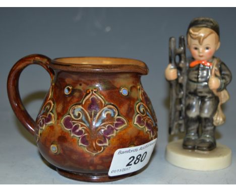 A Doulton Lambeth stoneware jug, c.1900; a Goebel Hummel figure (2)