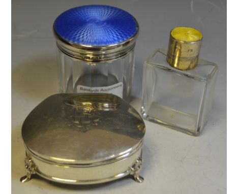 A silver jewellery box, supported on three feet, Birmingham 1907; a dressing table jar, guilloche enamel top; another (3)