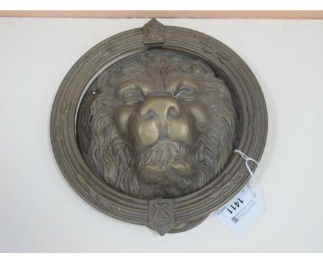 Brass door knocker in the form of a lions head and foliage read design to ring, approx 21cm w.