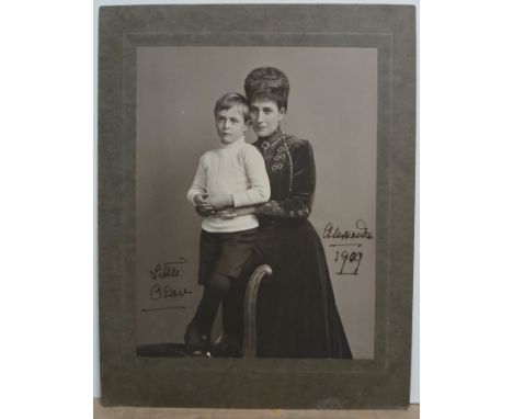 Queen Alexandra with grandson Prince Olav, autographed full length photographic portrait, signed and date3d 1909, unframed, 2