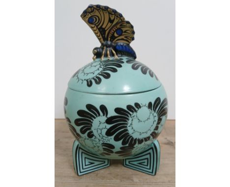 A Fraureuth Deckeldose Art Deco pottery casket of globular form with butterfly finial and three square section feet, height 1