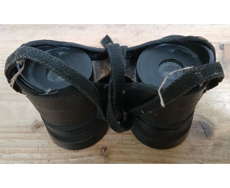 A pair of WWII commando binoculars with leather cover, strap and broad arrow marks.