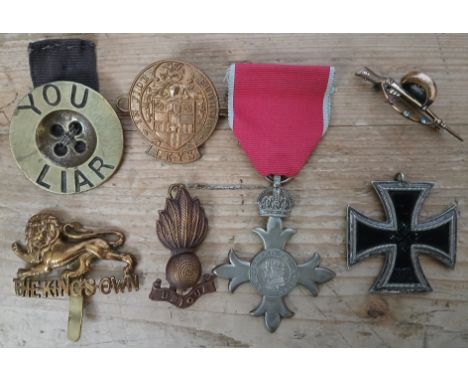 Assorted badges and medals including an OBE cross, a German 1939 Iron Cross, cap badges, sweetheart badge modelled as a rifle