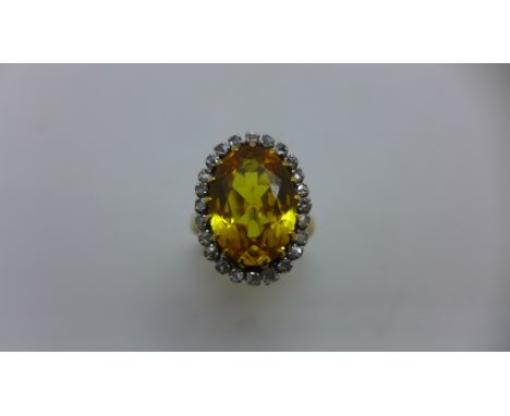 An 18ct yellow gold yellow sapphire ring. The yellow sapphire approx 14mm x 10mm x 5.5mm surrounded by small Diamonds , ring 