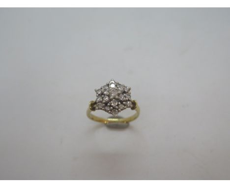 An 18ct yellow gold diamond cluster ring marked 18ct, ring size N, approx 4.3gs. Head measures 11mm wide. In generally good c