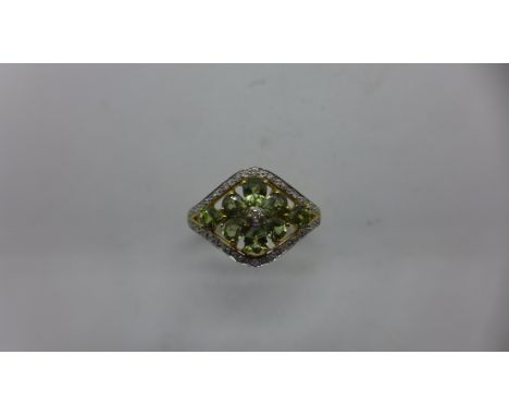 A hallmarked 9ct gold QVC floral design ring, possible tourmaline, size R, approx 3 grams in generally good condition 