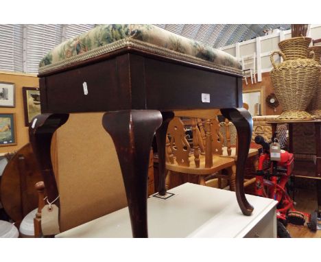 A Victorian upholstered foot stool resting on cabriole legs