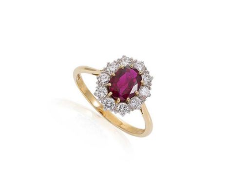 A ruby and diamond cluster ring set in 18ct gold, claw set central oval faceted ruby, 7.8 x 5.9mm, estimated approximate weig