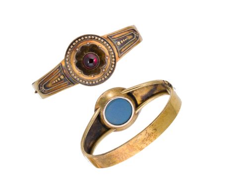 A Victorian garnet memorial bangle, central rubover set round cabochon garnet, diameter 8mm, carved floral border with applie