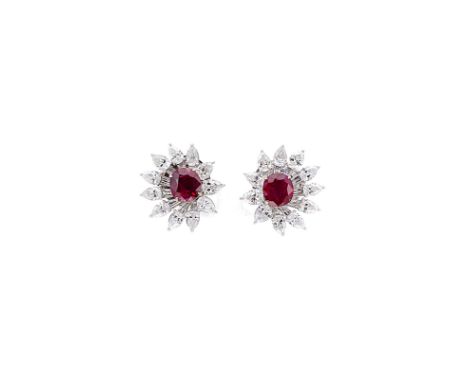 A pair of Burmese ruby and diamond cluster ear studs, each with a claw set central oval faceted ruby, surrounded by eight tap