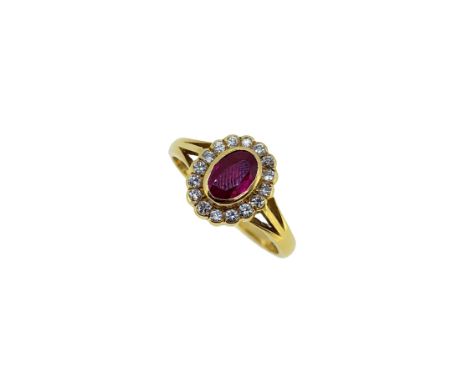 An 18ct gold ruby and diamond cluster ring, rubover set central oval faceted ruby, 6 x 4.5mm, estimated approximate weight 0.