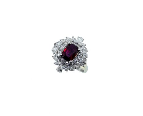 A Burmese ruby and diamond ring, claw set central rectangular cushion shaped ruby, 7.21 x 5.28mm, surrounded by a border of r