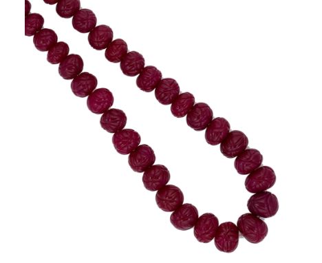 A necklace of carved ruby beads, thirty six graduated off-round carved beads totalling approximately 1000.00ct, diameter from
