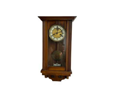 A late 19th century German spring driven wall clock in a mahogany case, with a flat top and full-length round topped glazed d