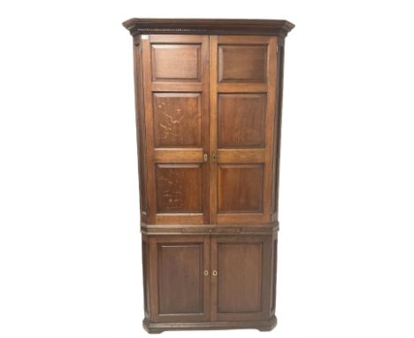 Oak Georgian double corner cupboard, the fixed dentil cornice over two doors, opening to reveal three fixed shelves, over one