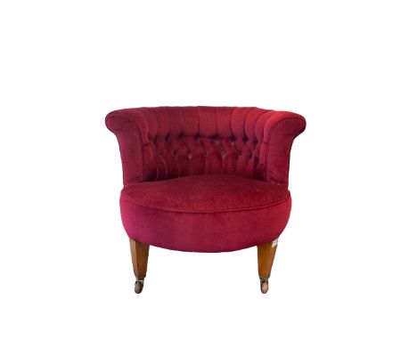Late Victorian tub-shaped salon chair, buttoned back upholstered in red, square tapering supports with brass and ceramic cast