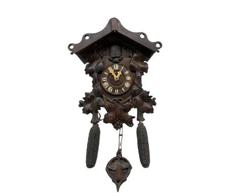 An early 19th century German Black Forest cuckoo clock in a carved oak case, 30-hour chain driven movement with wooden plates