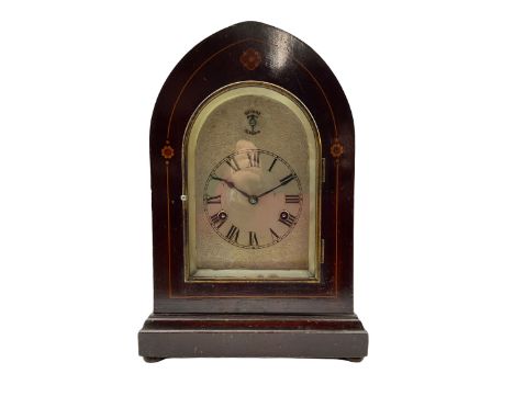 An Edwardian mahogany mantle clock with contrasting satinwood inlay c1905, in a lancet topped case on a projecting plinth wit