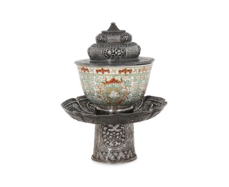 A TIBETAN SILVER CUP STAND AND COVER WITH XIANFENG PORCELAIN CUP Mid-19th century, lotus form stand decorated in eight panels