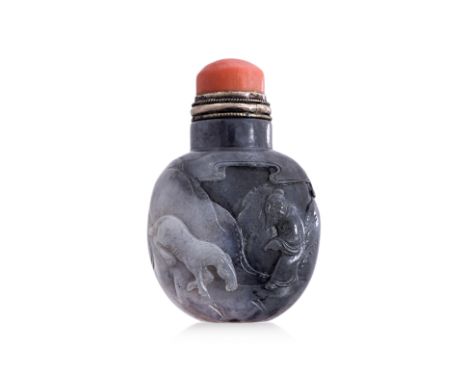 A BLACK AND WHITE JADE SNUFF BOTTLE
19th century, decorated in relief carved scene of man holding bowl beside pine tree, the 