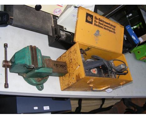 A metal bench vice together with tools