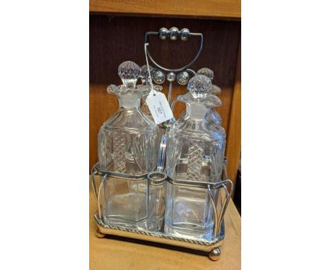 A silver plated and cut glass four bottle tantalus 