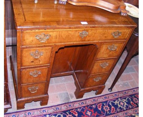 A Georgian ladies walnut writing desk with seven drawers to the front and cross banded top - 80cms wide