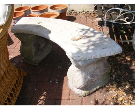 A curved stone garden bench