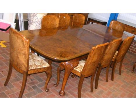 An Art Deco walnut extending dining table with the matching eight chairs, standing on carved cabriole supports - the table me