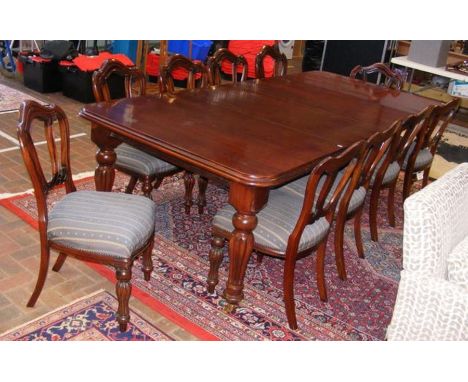 An extending mahogany dining table with two leaves and ten chairs - extended length approx. 260cms