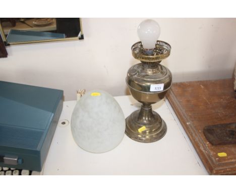 A brass oil lamp converted to electricity with mottled glass shade
