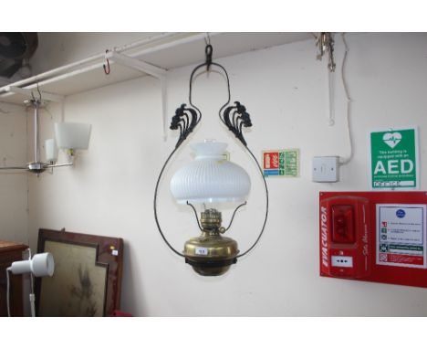 A brass and wrought iron hanging oil lamp