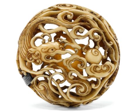 RYUSA-NETSUKE.Japan, 19. Jh. Ø 4,2 cm.Bein, Manju-förmig. Durchbrochen beschnitzt mit floralem Dekor auf der einen Seite. Die