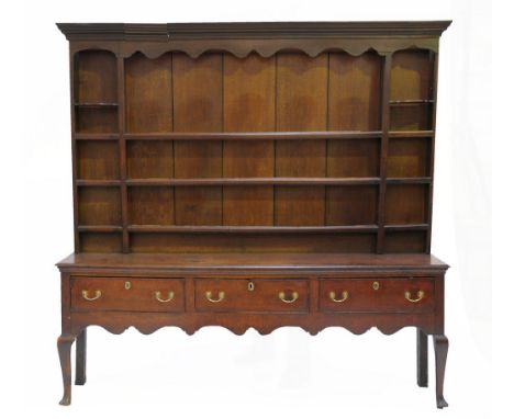 A George III oak high back dresser 
With a cavetto cornice above a shaped frieze, the boarded rack with three long shelves fl