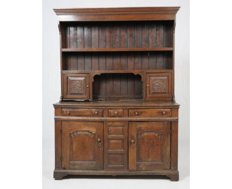 An 18th Century oak dresser base and rack
The associated boarded rack above a cavetto cornice and a plain frieze above a pair