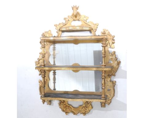 A Victorian giltwood and gesso mirrored wall shelf
With a stags mask pediment above four shaped shelves, enclosing two mirror