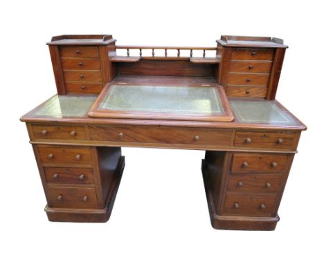 A mid-nineteenth century mahogany pedestal desk.  The rectangular moulded top with a hinged fall front inset with a green and