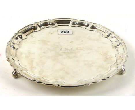 An Edward VII silver tray 
The circular scalloped tray with stepped rim, raised on three short scroll supports, inscribed wit