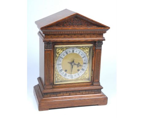 A Victorian oak cased mantel clock
With a 14cm brass and silvered dial, blued hands, Roman and Arabic numerals, leaf and scro