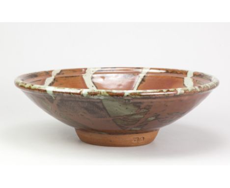 PHIL ROGERS (1951-2020); a very large stoneware footed bowl covered in kaki glaze with wax resist decoration, impressed PR an