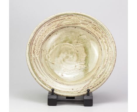 JIM MALONE (born 1946); a stoneware dish covered in green ash glaze with incised fish decoration, impressed JM mark, diameter