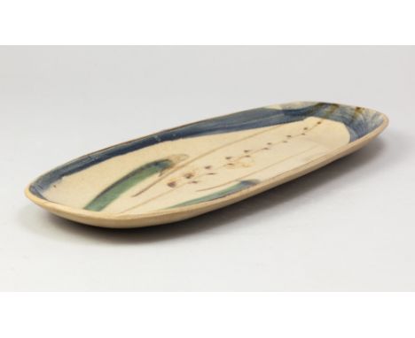 MICHAEL LEACH (1913-1985) for Yelland Pottery; a long stoneware dish with copper green and cobalt decoration on oatmeal groun