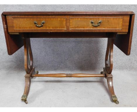 A Regency style mahogany drop flap sofa table with two dummy drawers opposing a pair of drawers. Raised on lire stretchered s