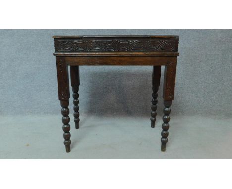 A late 19th Century oak writing desk with floral carving and bobbin turned supports. H.70 W.66 D.42cm 