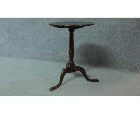 An antique country oak tilt top circular tea table raised on tripod supports. H.67 W.47cm 