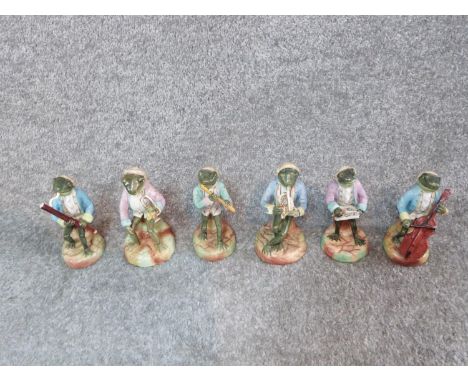 A collection of six antique porcelain hand painted Sitzendorf frog musicians. Includes flute, cello, tuba, violin, bassoon an